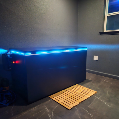 Black matte Plunge Zero HardTop cold plunge tub with blue lighting in a modern gray room.