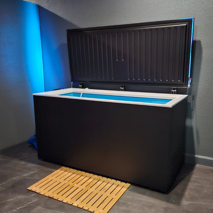 Black matte Plunge Zero HardTop cold plunge tub with blue lighting in a modern gray room.