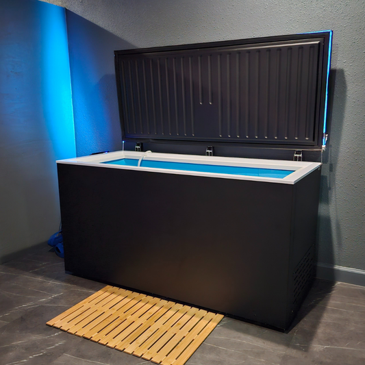 Black matte Plunge Zero HardTop cold plunge tub with blue lighting in a modern gray room.
