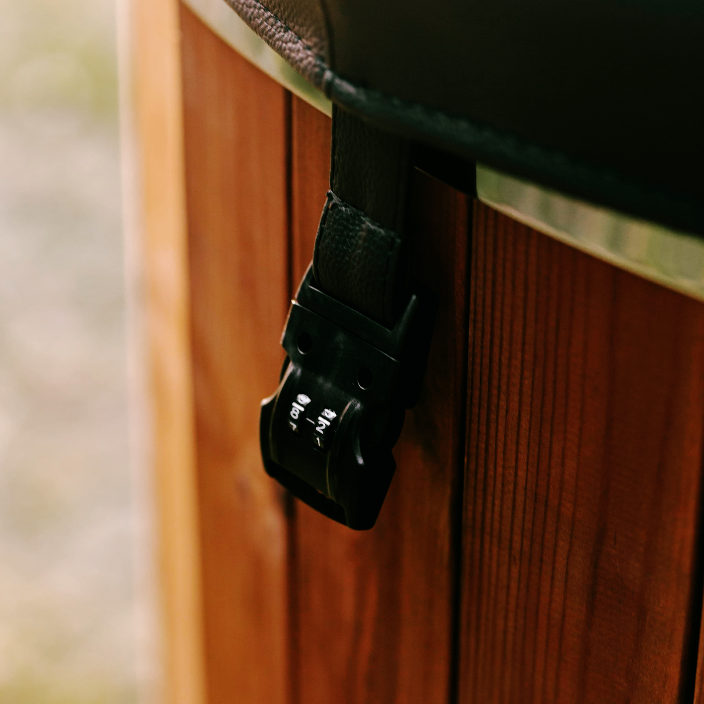 Close-up of a black strap buckle on a wooden surface