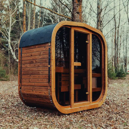 Fully assembled Mande Spa USA MW12 outdoor sauna with Bituminous roof in a peaceful forest setting, featuring a compact ThermoWood® design for backyard wellness and home spa use.