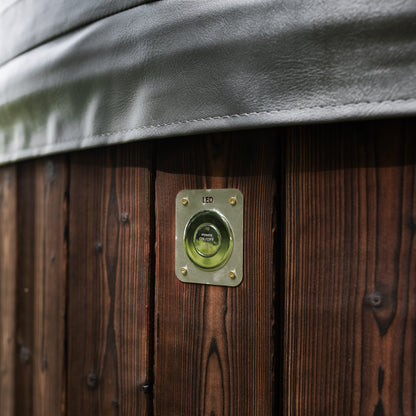 Hot tub with wooden exterior and control panel on a wooden deck