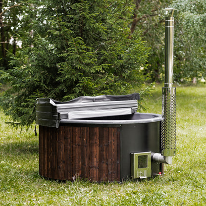 wood-fired hot tub with wooden exterior and metal chimney in a forest setting.