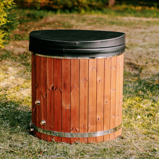 Wooden hot tub with black lid on grass