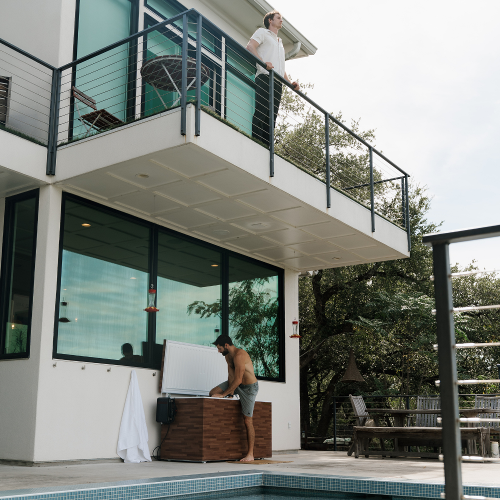 Modern house with a pool area with cold plunge tub where people are gathered.