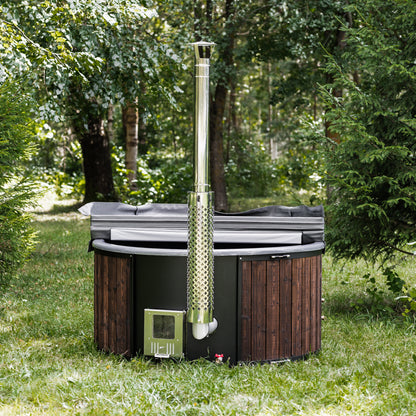 wood-fired hot tub with wooden exterior and metal chimney in a forest setting, designed for backyard relaxation and natural wellness.