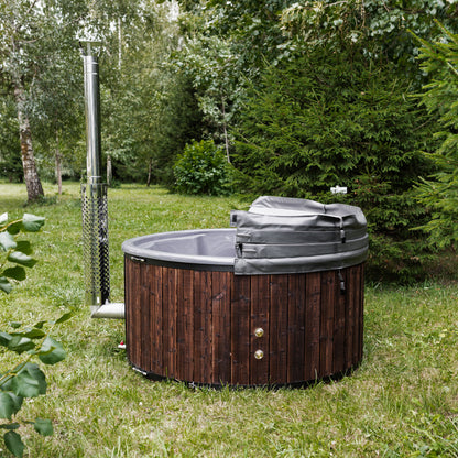 Hot tub with wooden exterior and gray interior in a grassy outdoor setting