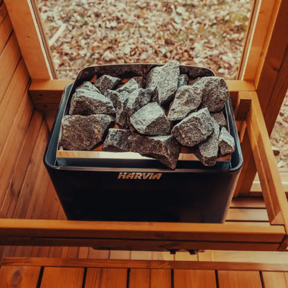 View of a Harvia electric sauna heater from inside the Mande Spa sauna, featuring a warm wooden interior for an authentic home spa experience.