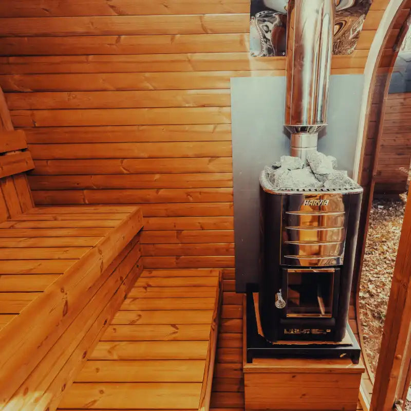 View of a wood-burning sauna heater from inside the sauna, featuring a warm wooden interior for an authentic home spa experience.