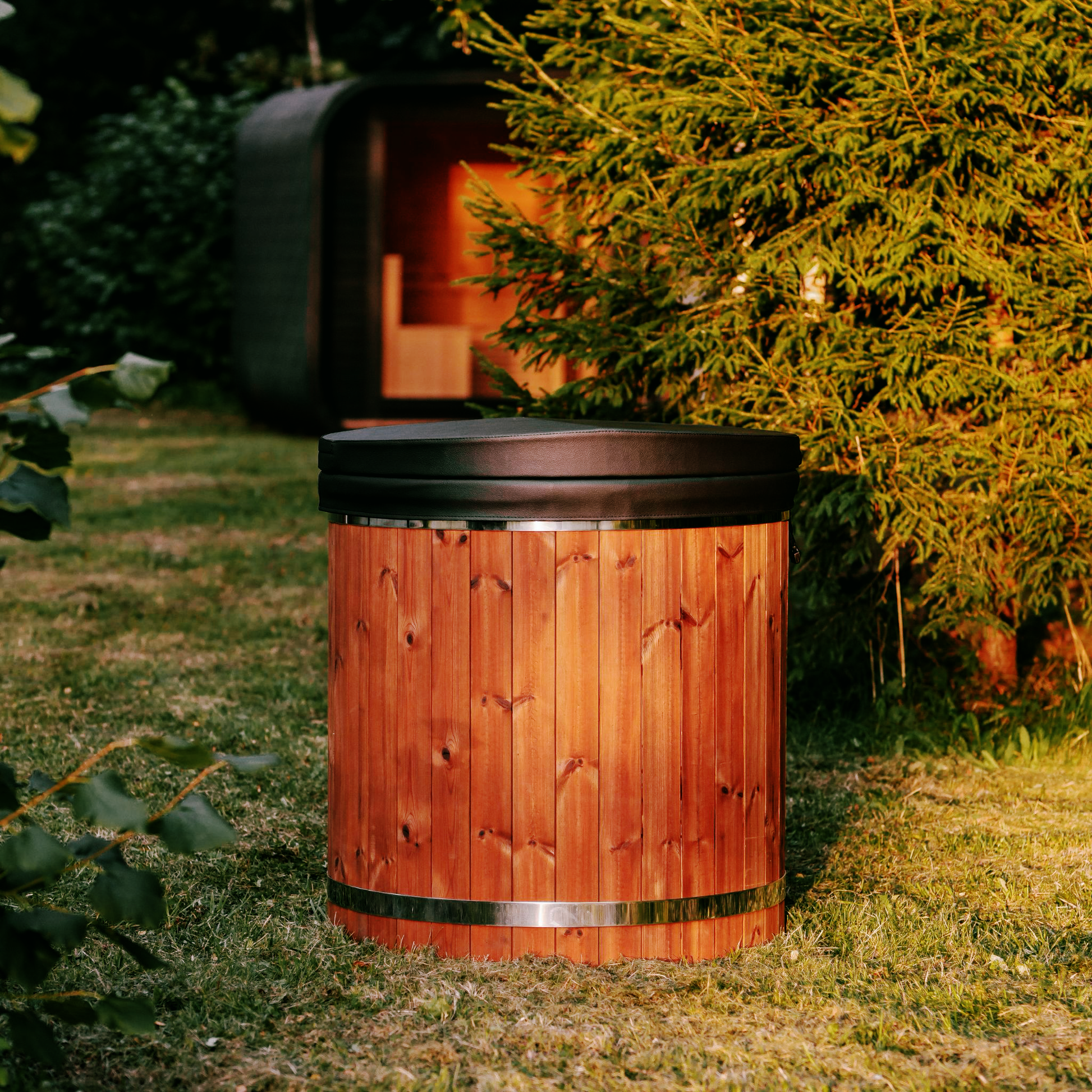 Wooden hot tub in a garden setting with greenery